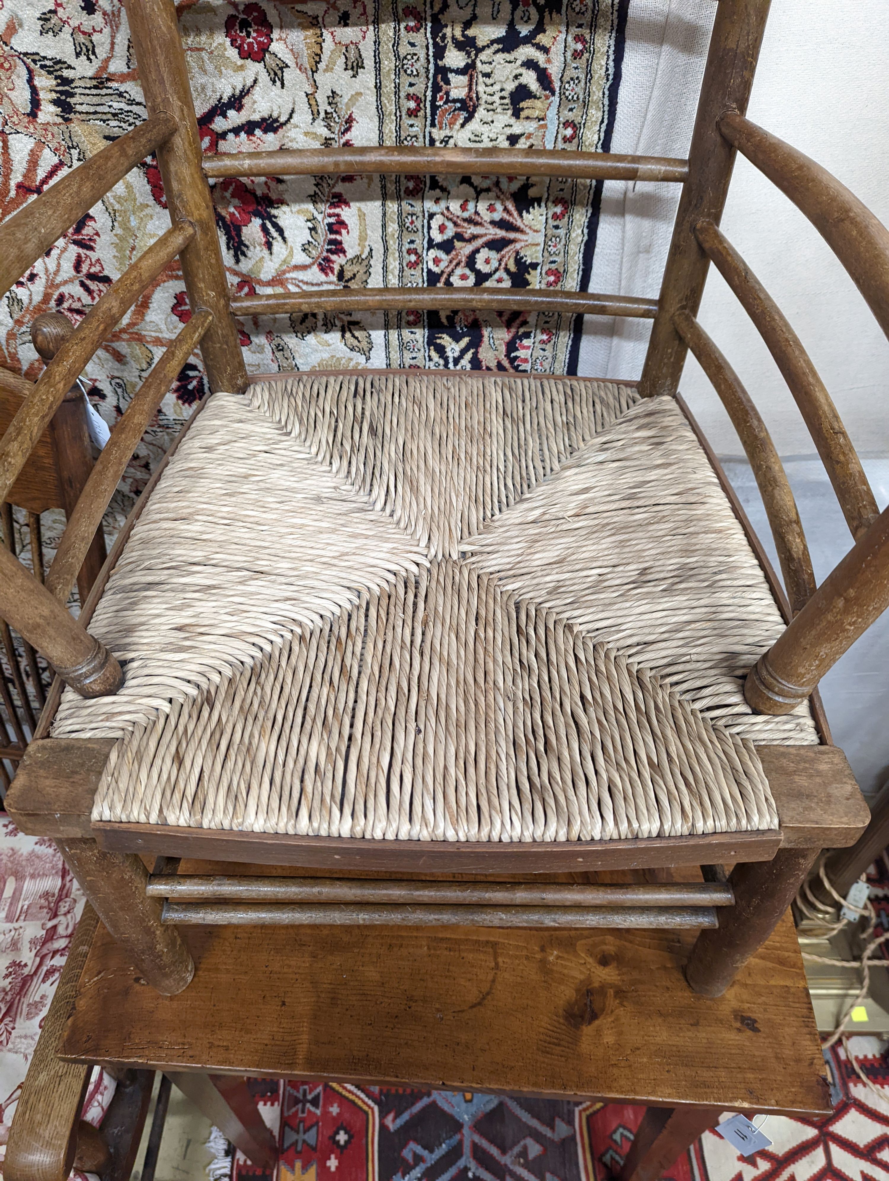 A late 19th century beech rush seated Sussex elbow chair, (cut down) width 55cm, depth 44cm, height 81cm